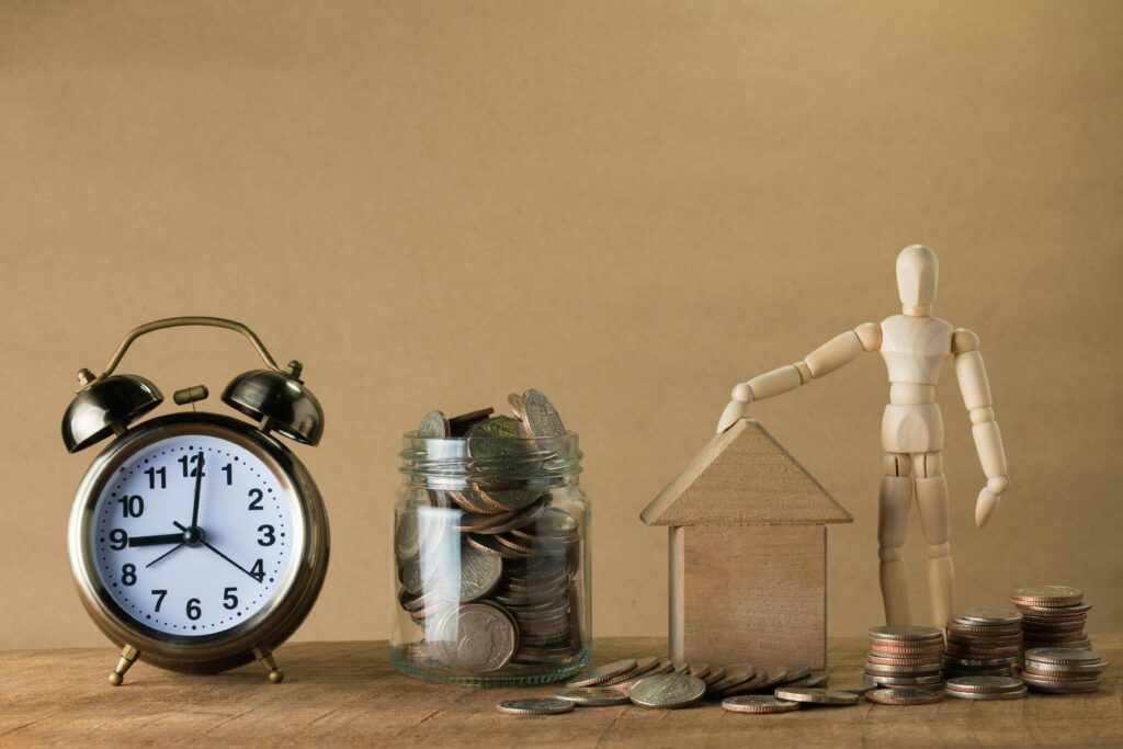 How Long Does It Take to Make Money Selling Digital Products Clock, coins, and house model representing time and profit from selling digital products online